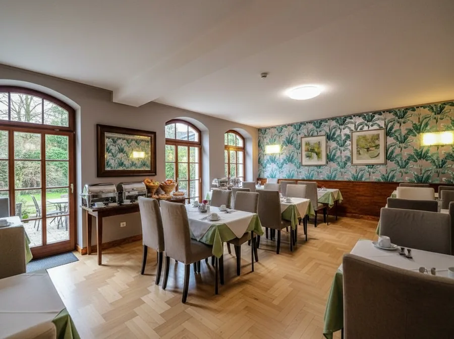 Frühstücksraum eines Gästehauses mit gedeckten Tischen und Buffet